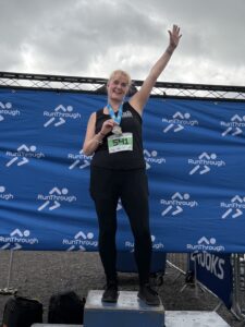 Claire with her 10K medal on the podium